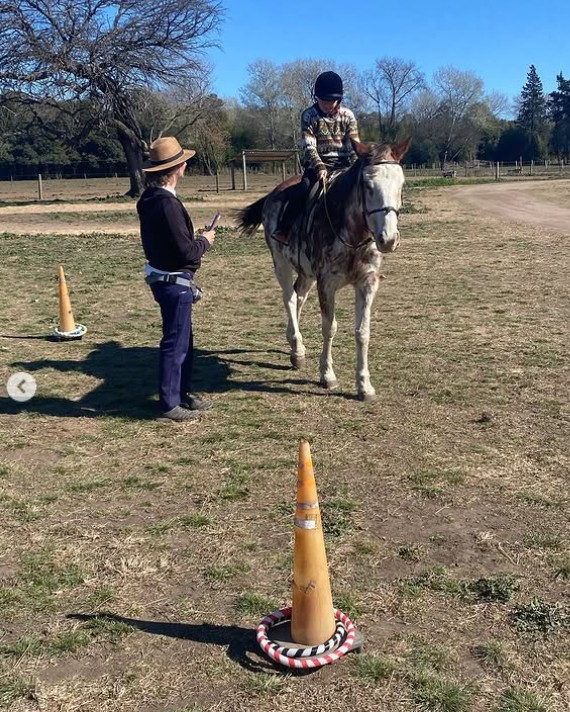 Paciente montando a caballo entre conos durante ejercicio terapéutico